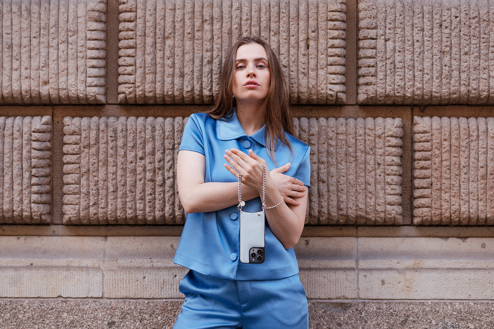 Model showcasing stylish outfit from the Ice Collection, posing confidently against a textured wall.