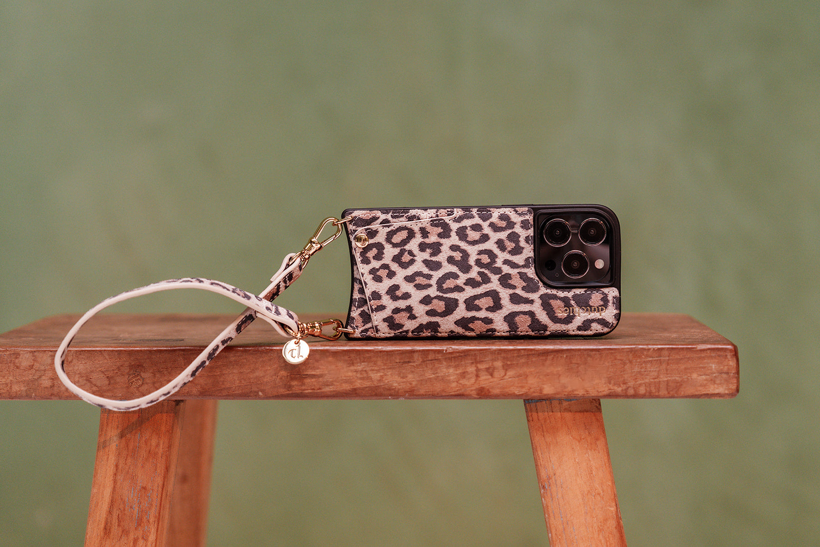 Leopard collection phone case on a wooden table with a stylish strap.