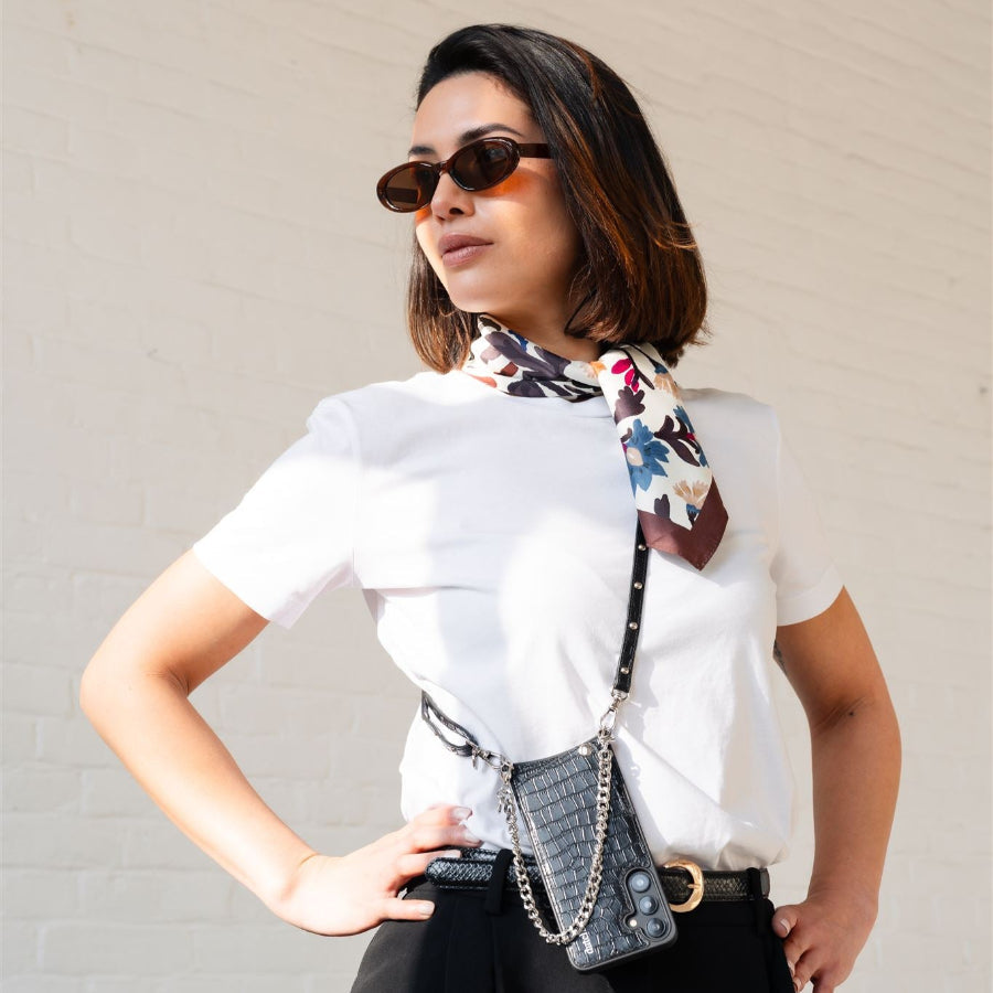 Stylish woman in sunglasses with a scarf, showcasing accessories from the Noir Silver collection.