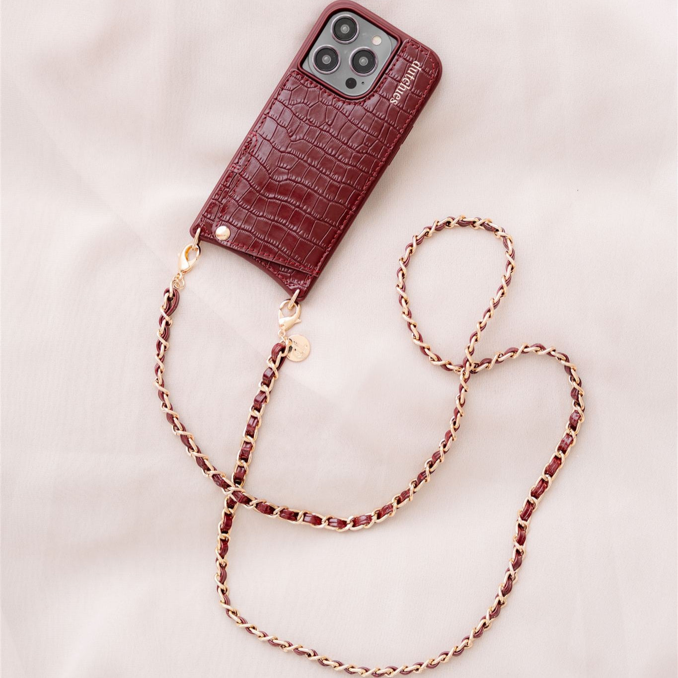 Elegant burgundy phonestrap case with a chic chain, featured in the All Phonestraps collection.