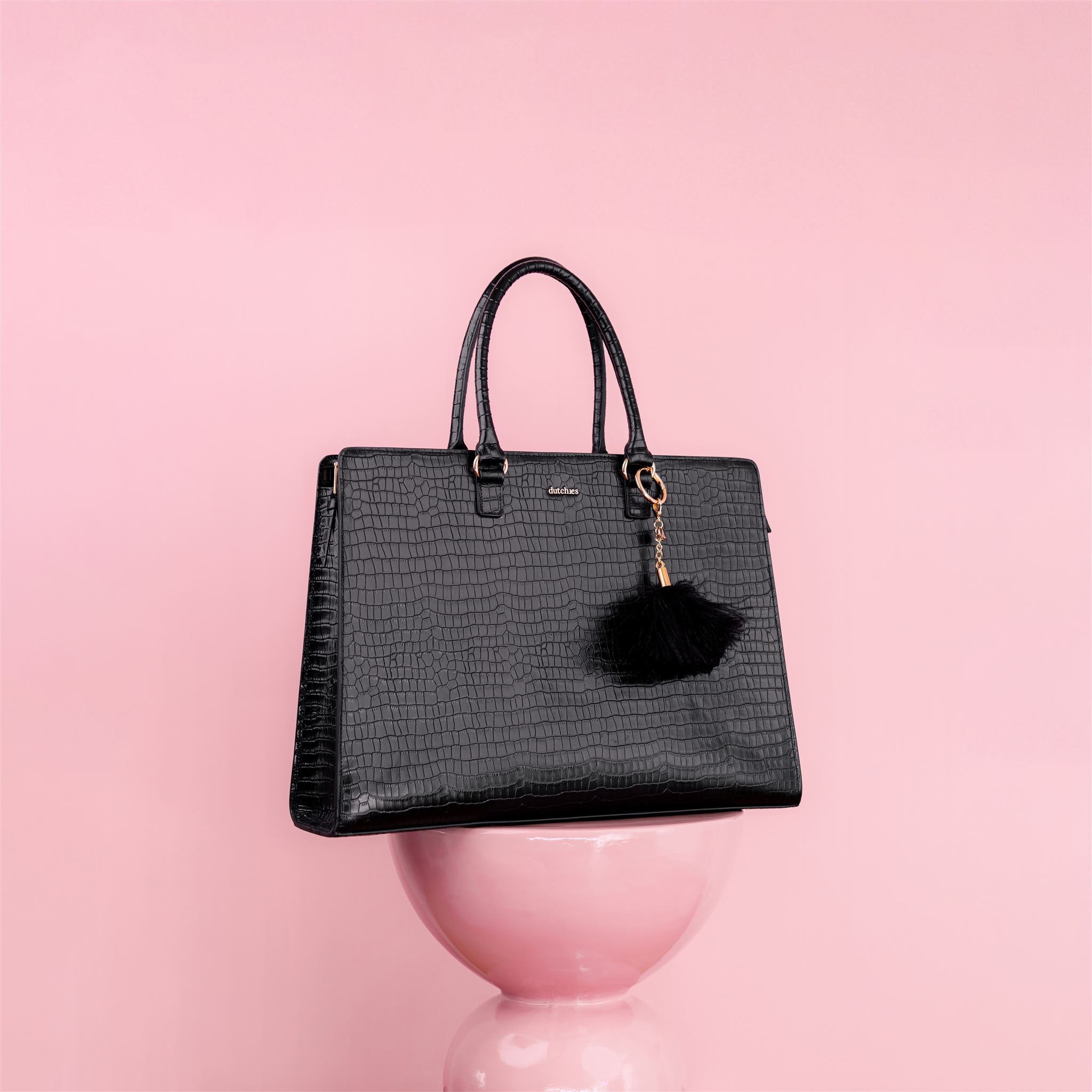 Stylish black handbag with a faux fur tassel, perfect for elevating any outfit. Explore our collection of Bags.