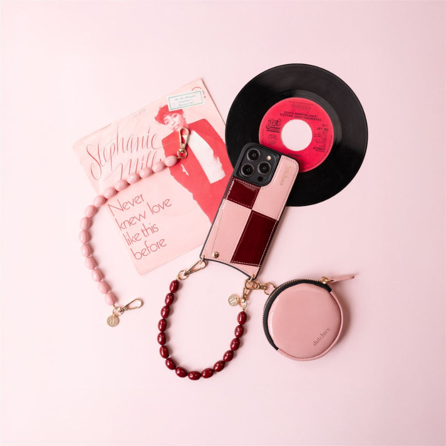 Phone Charm | Beaded | Charley with record, phone case, and accessories on a pink backdrop.