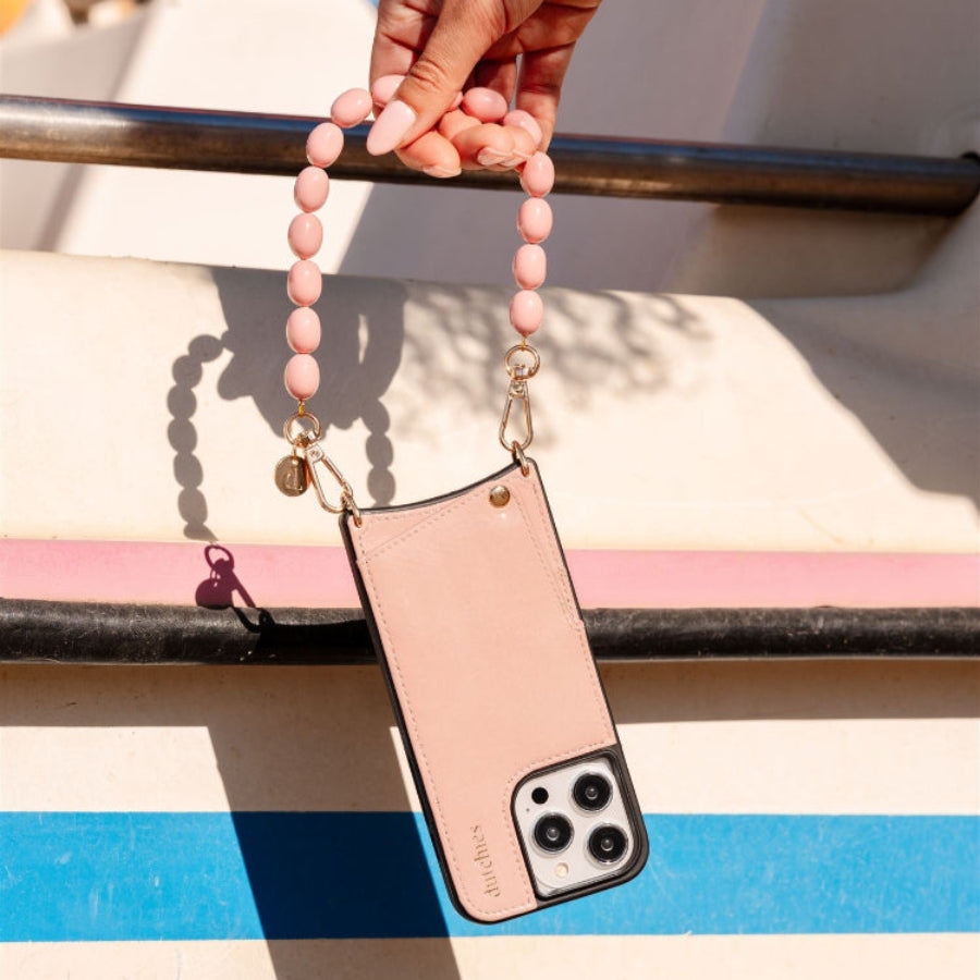 Stylish pink phone charm with high-quality beads attached to a phone case, perfect for accessorizing your device.