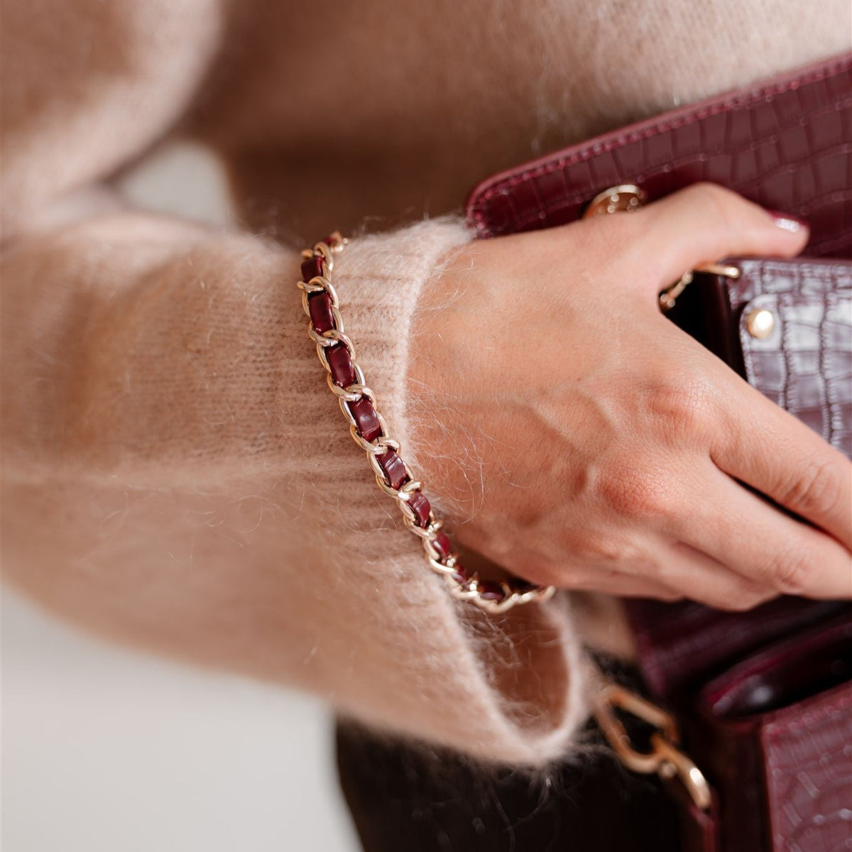 Modischer Handyanhänger | Italian | Burgundy kombiniert mit einer stilvollen Handtasche und einem kuscheligen Pullover.