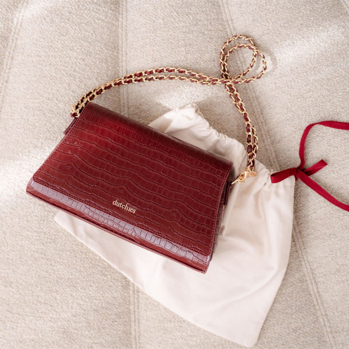 Sophie Crossbody Bag | Burgundy with gold chain strap on a neutral background, perfect for stylish outings.