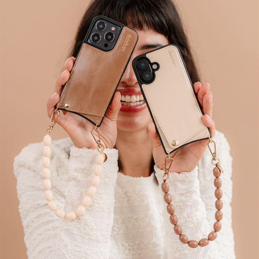 Model showcasing Rachel phone charms on two stylish phone cases, highlighting a chic and functional design.