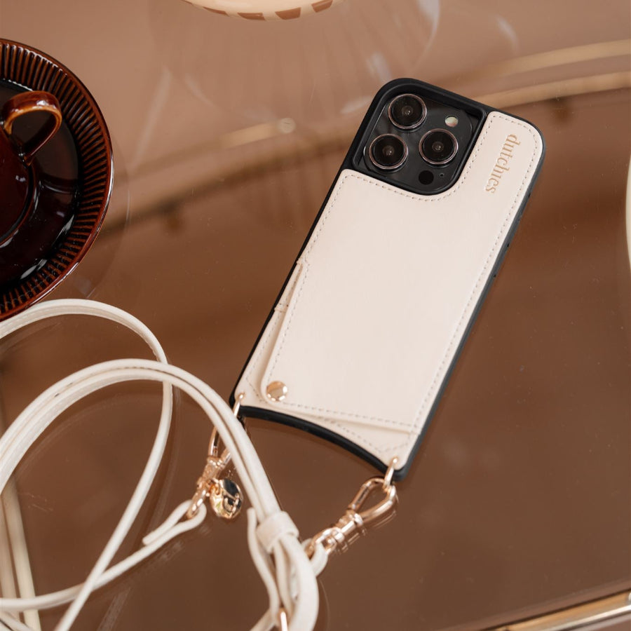 iPhone Case | Vanilla handmade leather case with cardholder and strap on a stylish table.