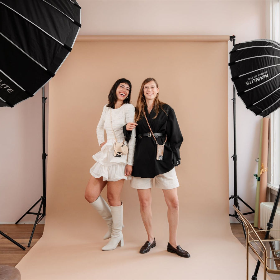Two women posing stylishly in a studio, showcasing the iPhone Case | Vanilla with trendy outfits.