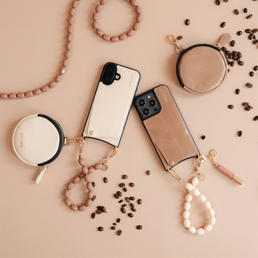 Stylish phone charms and cases in neutral tones on a beige background with decorative beads and coffee beans.
