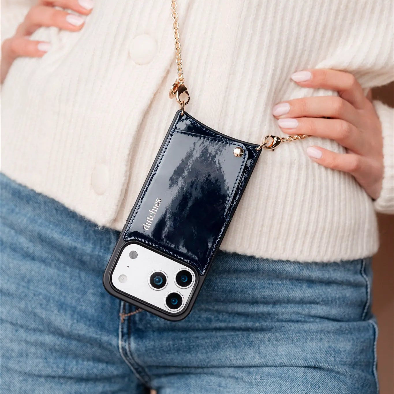 Person holding a navy blue phone case with a chain phone strap