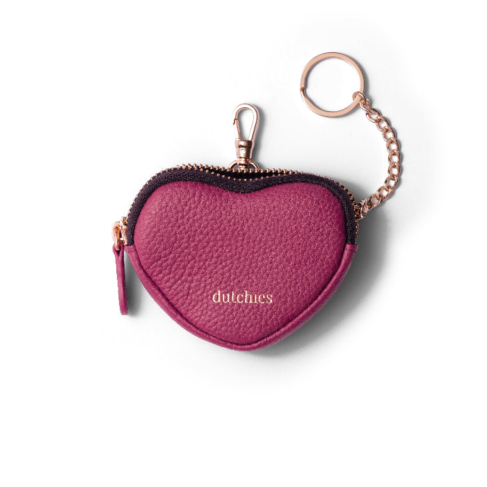 A purple heart-shaped leather mini phone bag with a keychain attachment and the brand name 'dutchies' visible.