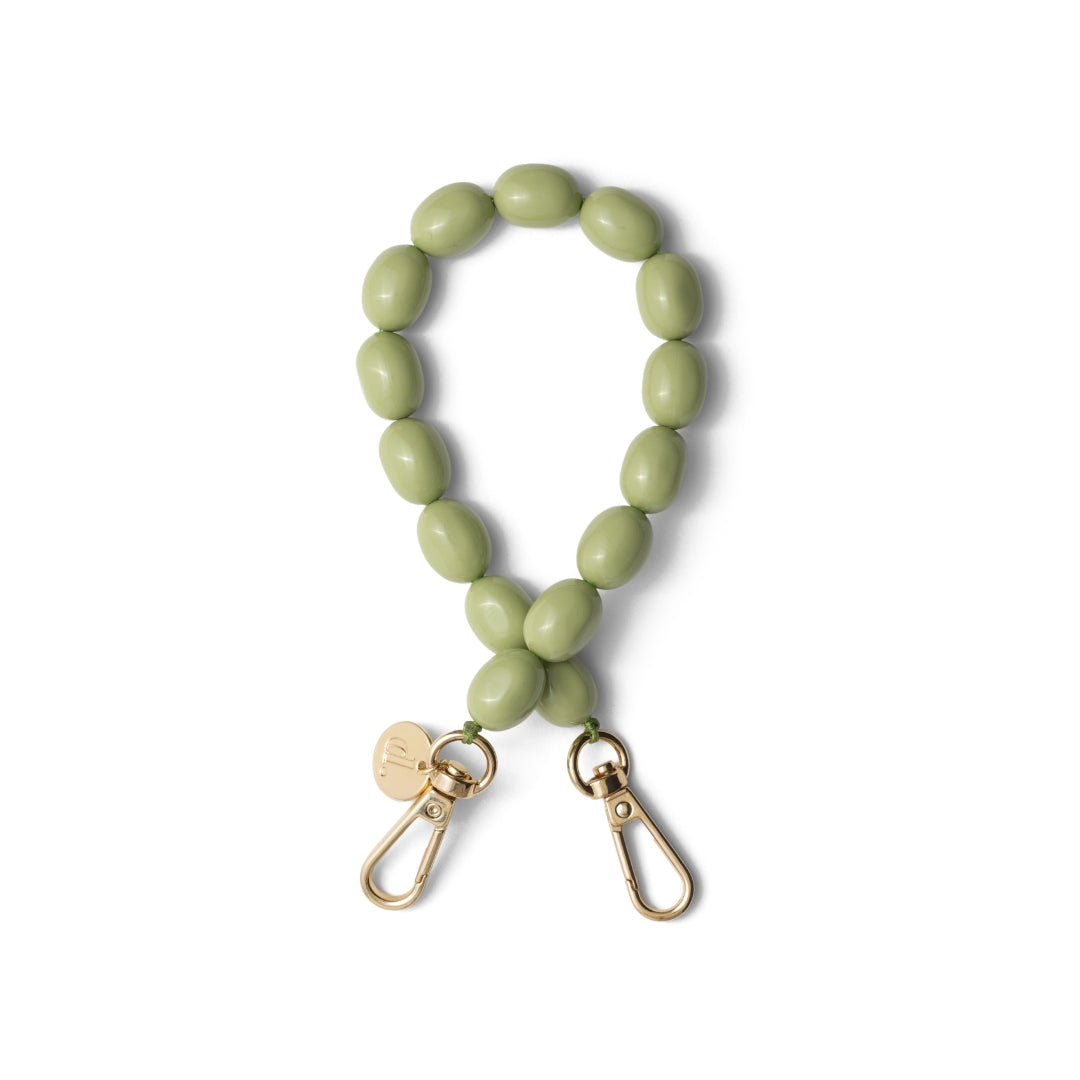 Beaded phone charm in light green with gold hardware, inspired by artist Clara Peeters.