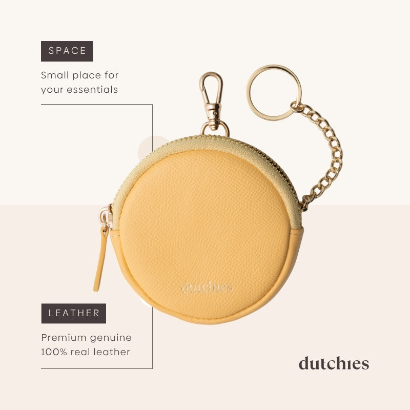 Mini Phone Bag Emma | Yellow - round leather pouch for storing essentials with clip and keychain.