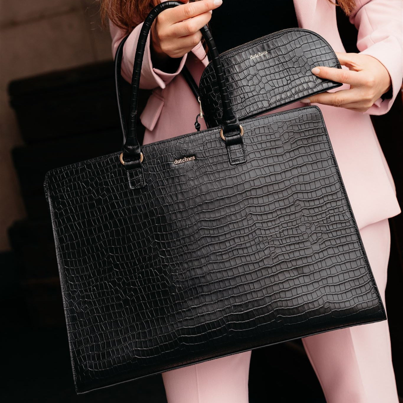 Stylish black leather handbag with a matching pencil pouch, perfect for work or makeup essentials.