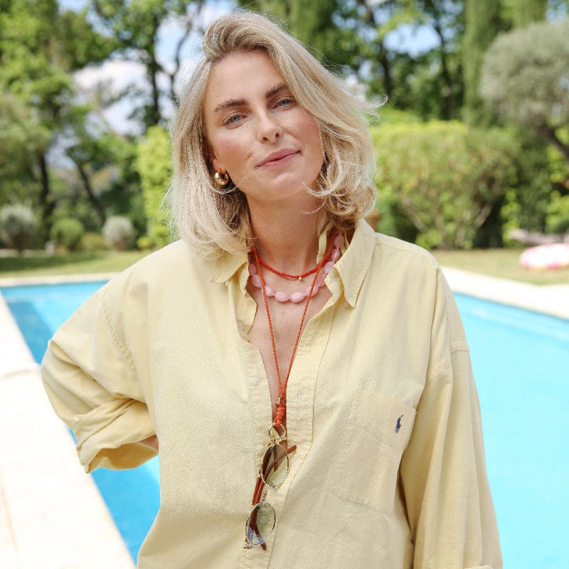 Sunglass Strap | Orange worn by a woman by the pool, stylish and practical accessory for securing sunglasses.