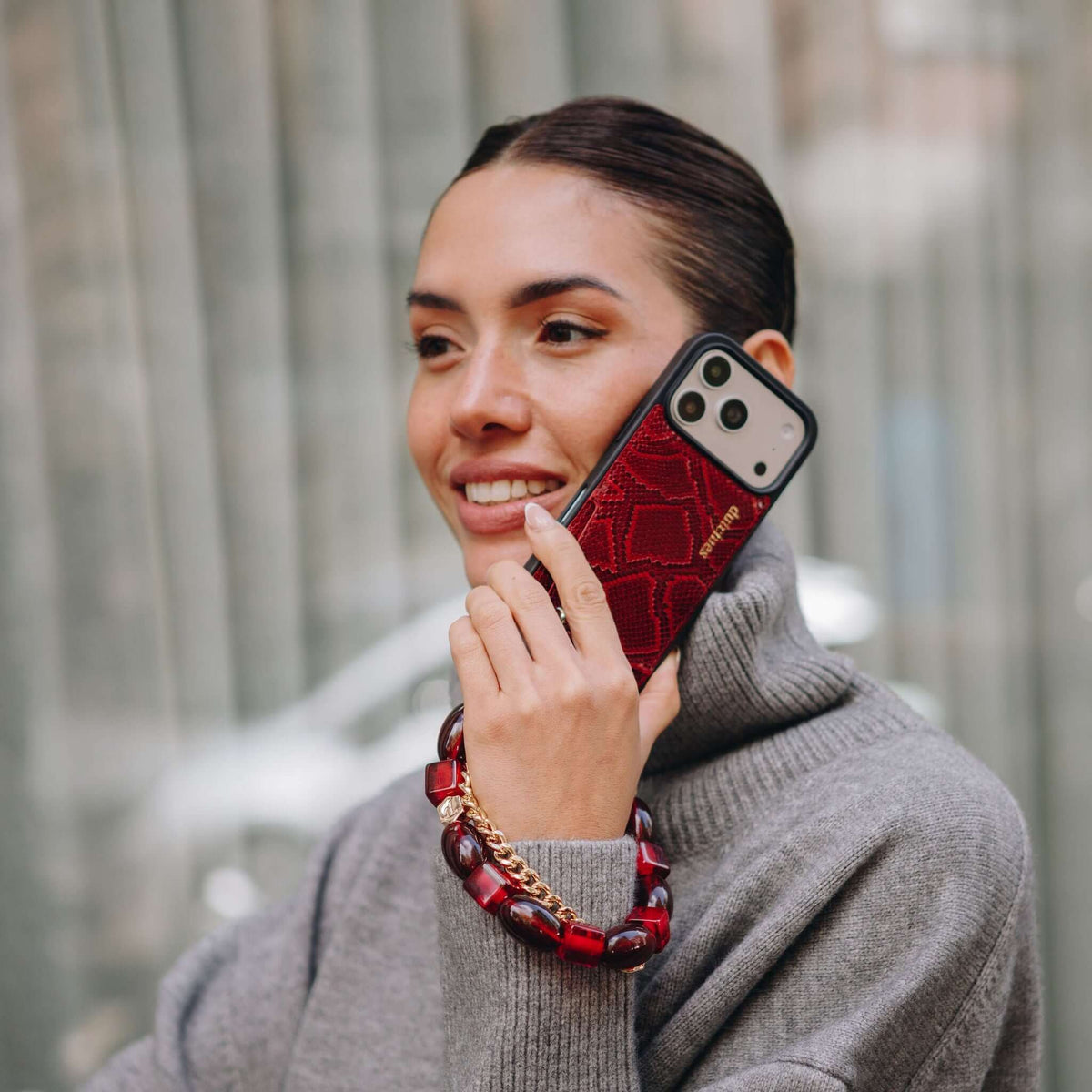 Charm Set | iPhone | Snake Red | Franky - stylish woman holding a phone with a trendy snake red case and phone charm.
