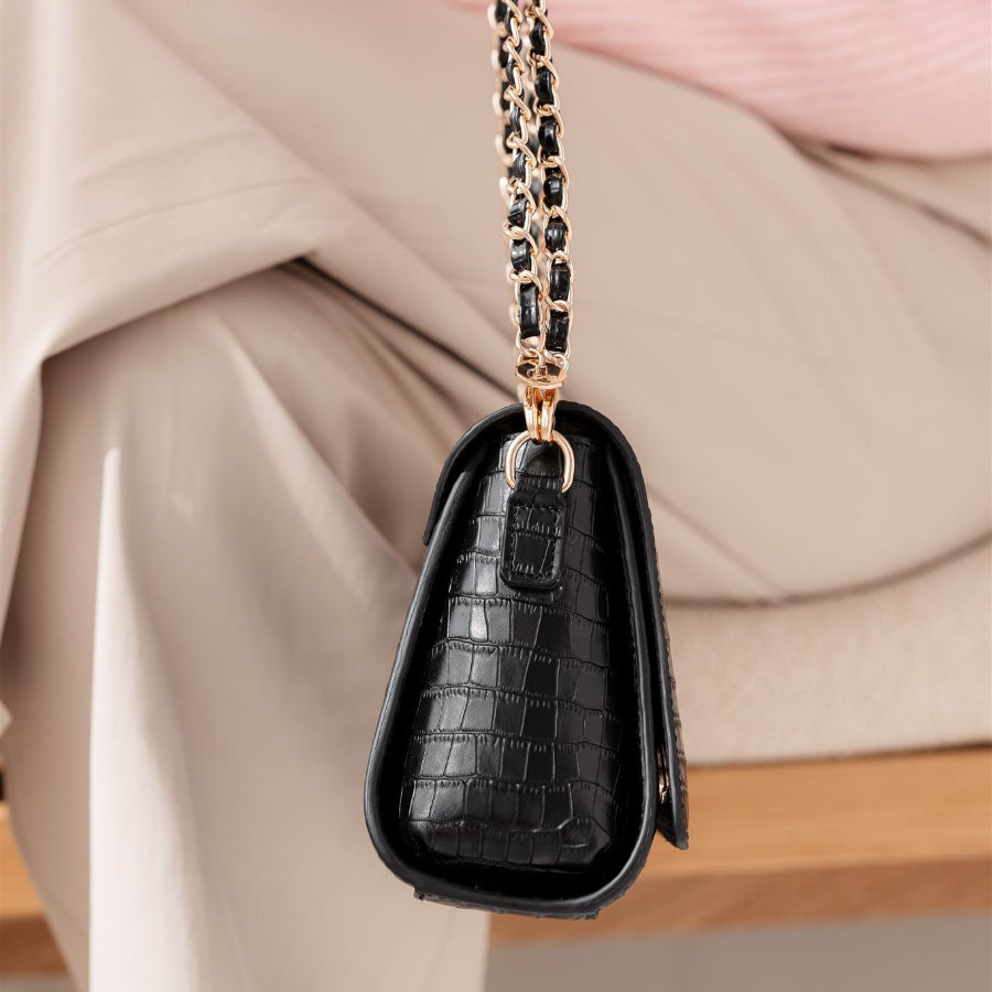Sophie Crossbody Bag | Noir Gold, der fremviser et eksklusivt læderdesign med en chic kæderem, perfekt som en stilfuld telefonpose.