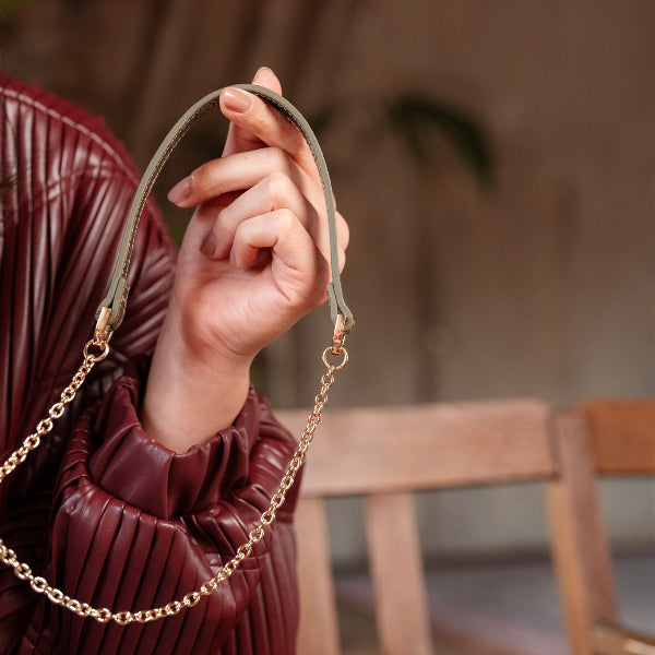 Woman holding a Phone Chain | Spanish | Olive Green with stylish gold accents.