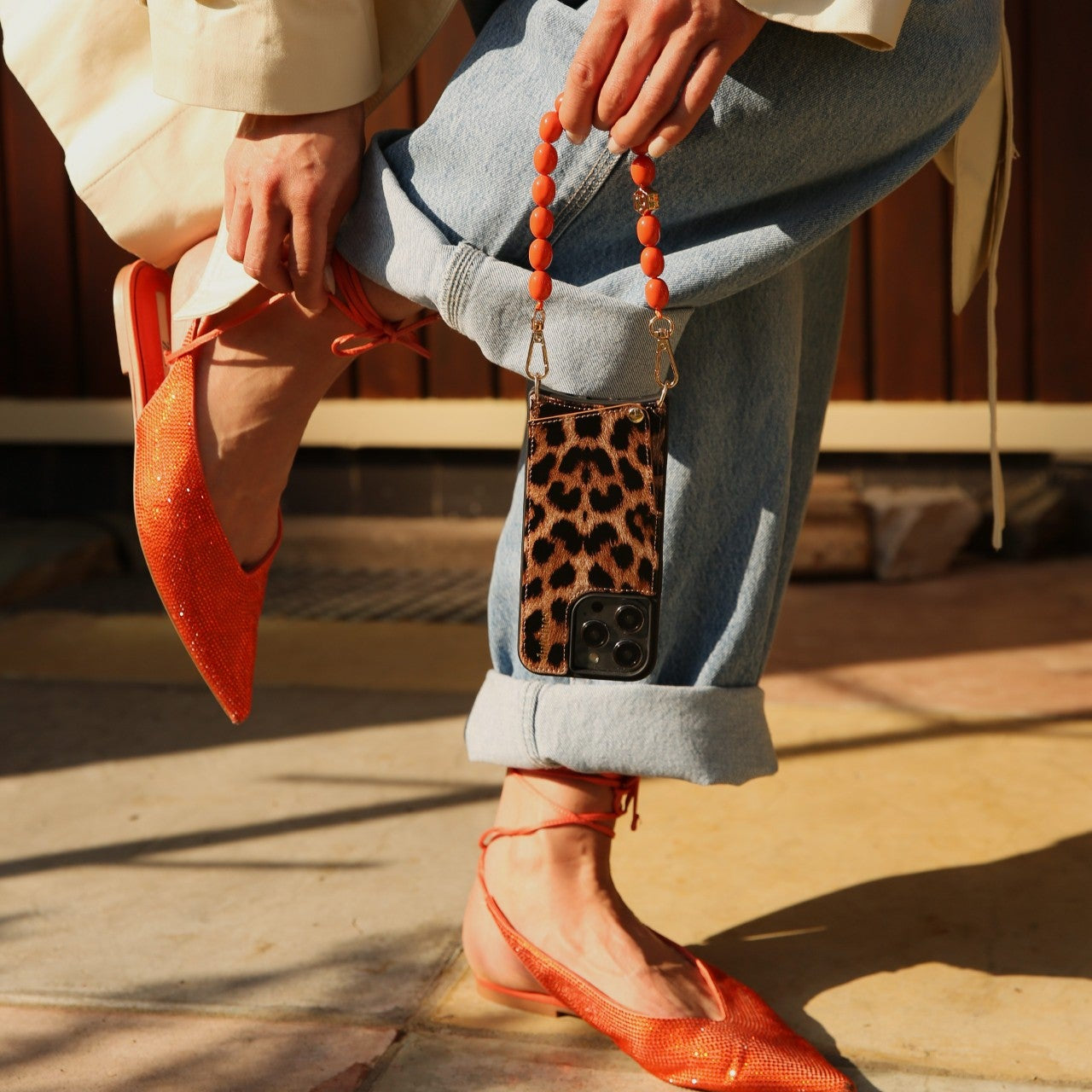 Phone Charm | Beaded | Tamara in vibrant orange with chic leopard print phone case, stylishly accessorized.