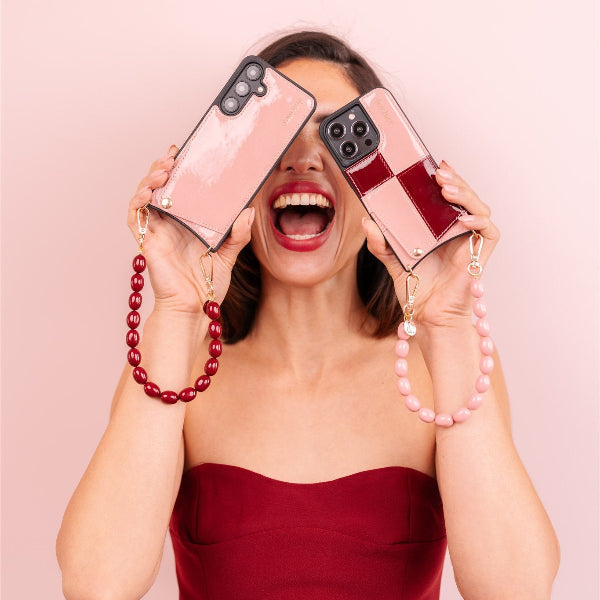 Model in a polka dot dress joyfully showing off a stylish phone case from the Lollipop collection.