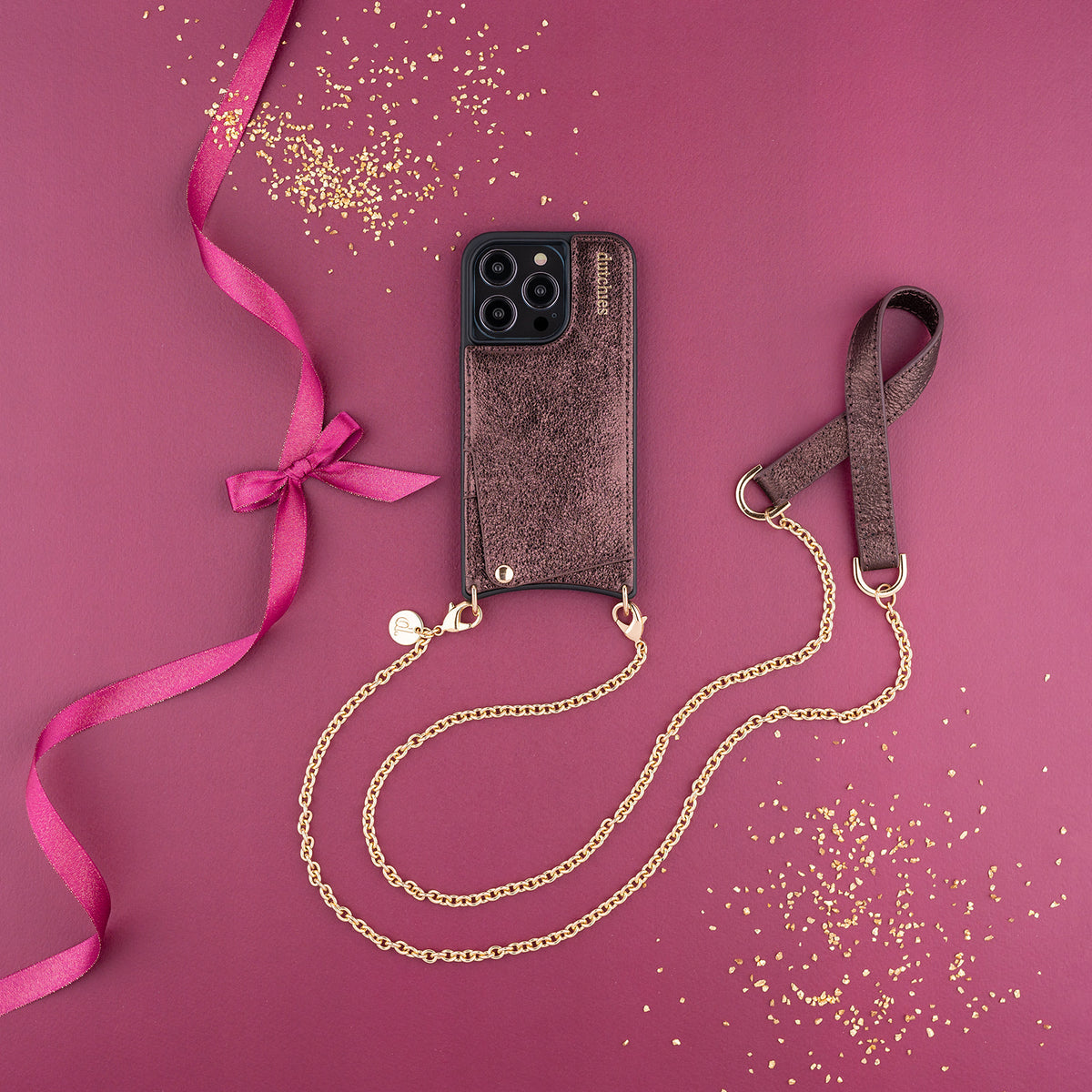 Phone Chain | Spanish | Copper with a trendy gold chain and stylish phone case on a pink background