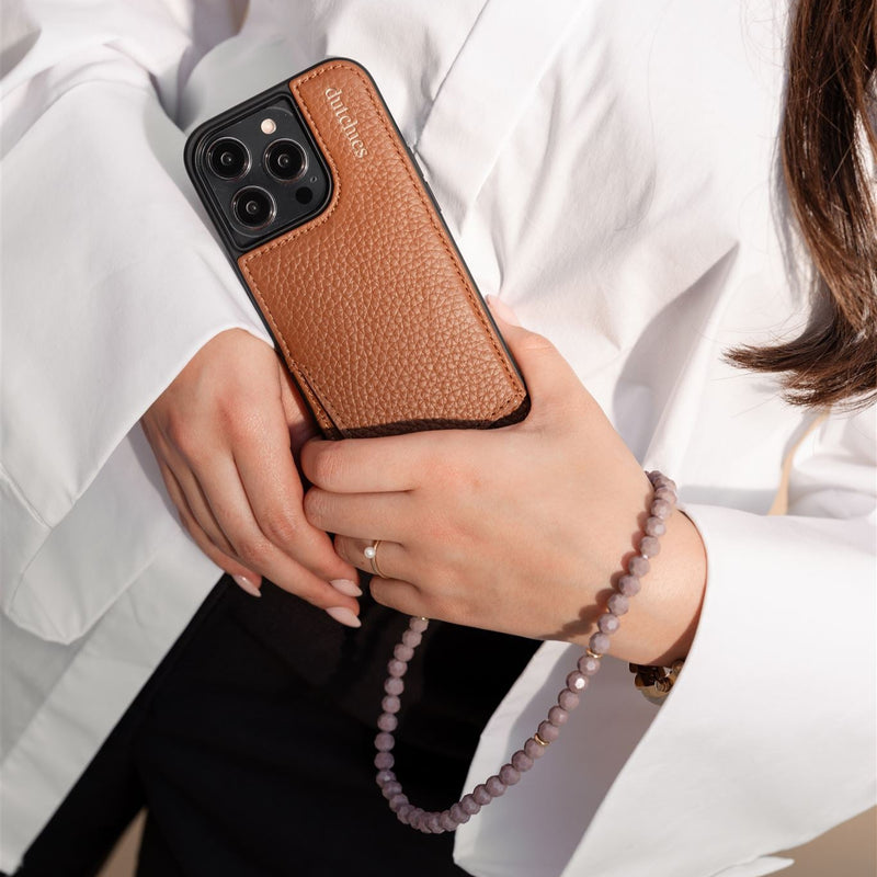 Phone Charm | Beaded | Aletta elegantly accessorizing a phone in a stylish brown case.