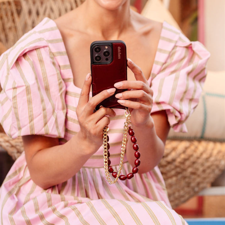 Phone Charm | Gold | French held by a woman in a stylish dress, showcasing its elegant design and functionality.
