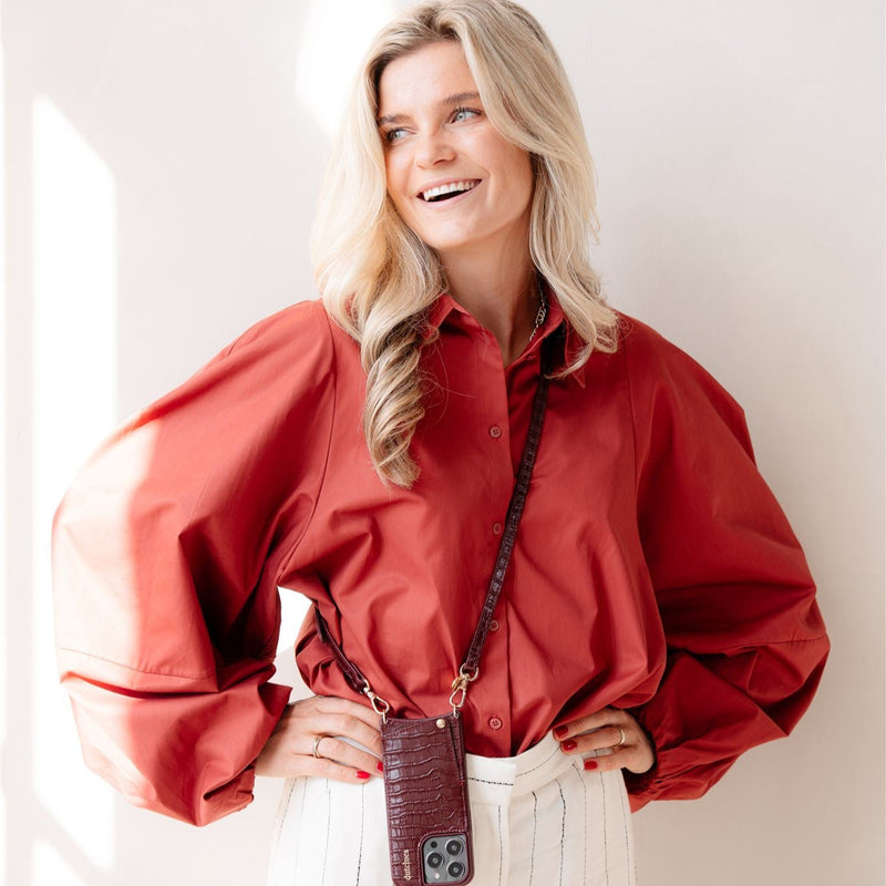 Classic set | iPhone | Burgundy - Stylish woman wearing a burgundy phone case with cardholder and strap.