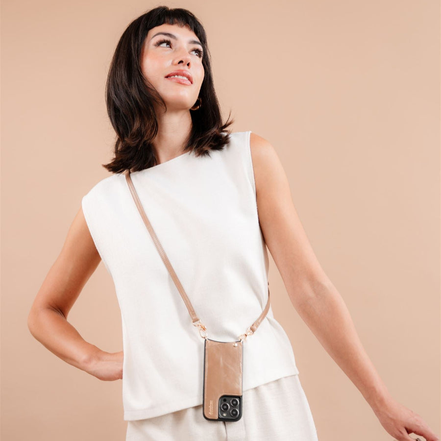 Model präsentiert die iPhone Hülle | Mocha, stilvoll getragen mit einem Strap für einfachen Zugriff und Schutz.