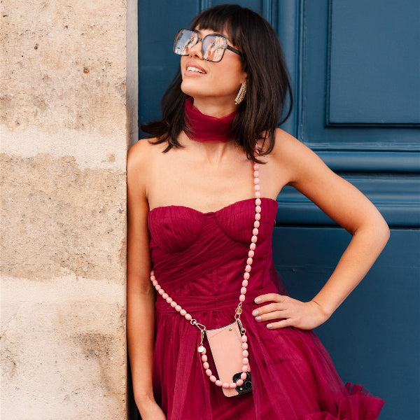 Phone Chain | Beaded | Therese in pink, stylishly worn as a crossbody phone chain by a model in a glamorous dress.