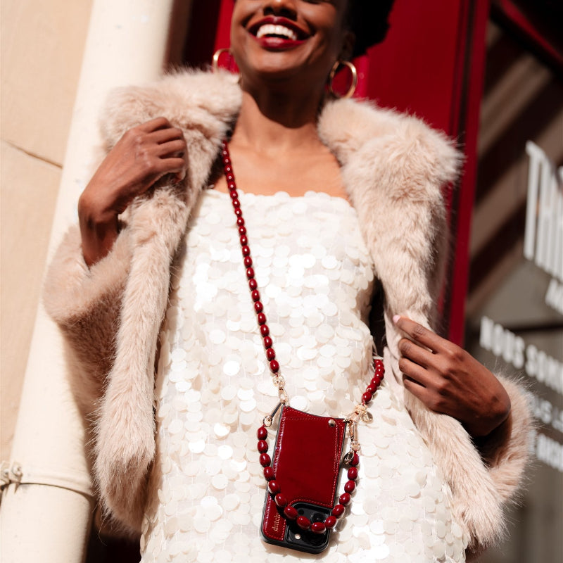 Beaded Phone Chain | Charley stylishly worn on a model with a burgundy phone case and chain, exuding elegance.