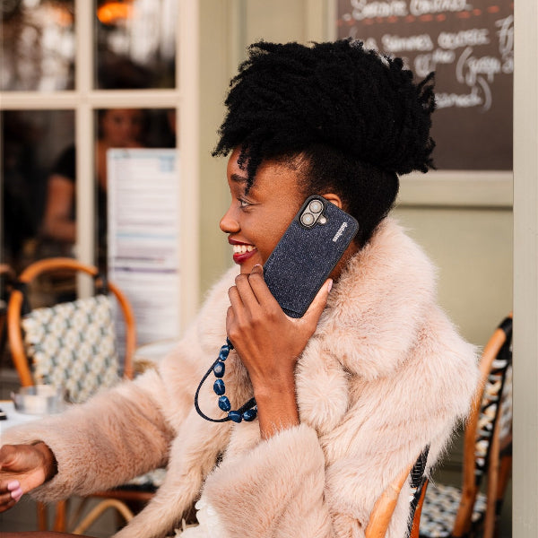 Phone Charm | Beaded | Diana in use with a stylish woman, showcasing a blue mobile phone charm.