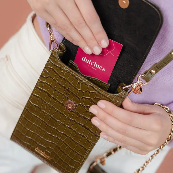 Phone Bag Juliet | Olive Green with a hand reaching for a card, showcasing its stylish, practical design.