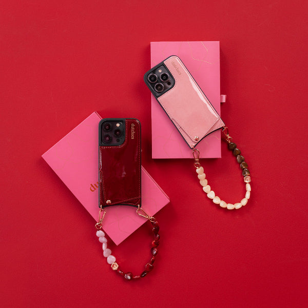Phone Charm | Beaded | Amora phone charms in brown and beige colors on a vibrant red background.