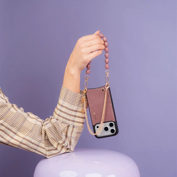 Phone Charm | Beaded | Eileen in soft mauve hanging from a hand, showcasing a stylish mobile phone accessory.