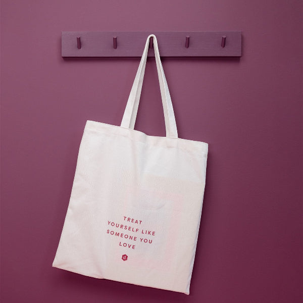 Totebag hanging on a wall with a motivational quote, perfect for carrying essentials.