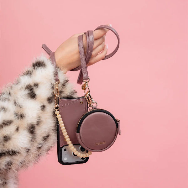 Phone strap | Slimline | Mauve stylishly holding phone case and pouch against a pink background.