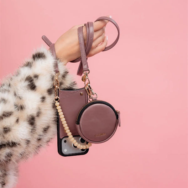 Luxury Set | iPhone | Mauve hand holding stylish mauve phone case and accessory on pink background.