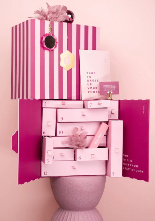 Adventbox - Pink and white beauty product set with striped box on a pink background