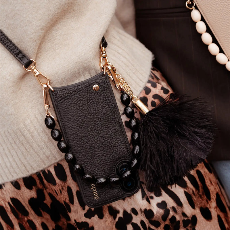 Phone Charm | Beaded | Louise featuring black beads and a fluffy pom-pom attached to a mobile phone case.