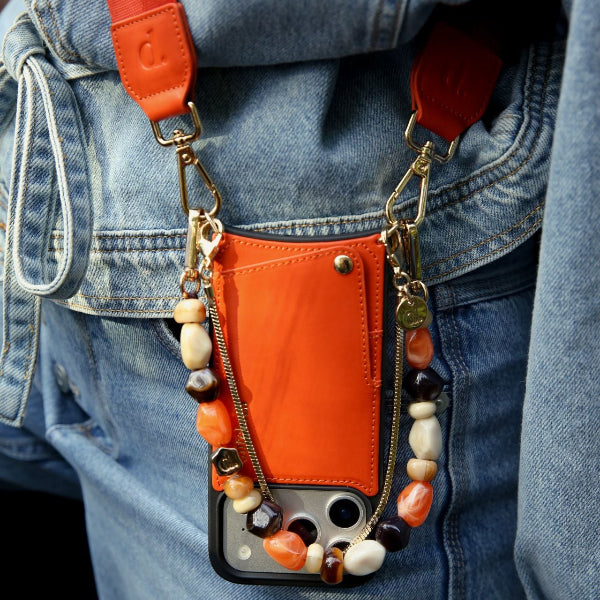 iPhone Case | Orange with beaded strap and cardholder attached, showcasing leather design and practicality.