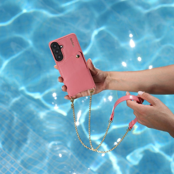 Phone Chain | Spanish | Pink held by a hand above a blue swimming pool.