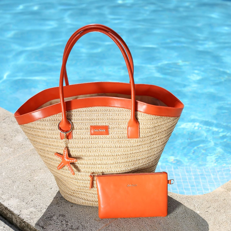 Beach Bag Set | Raffia Orange by the pool, showcasing a stylish straw bag and bright orange wallet.