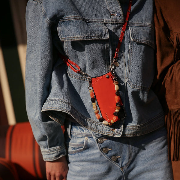 Phone strap | Slimline with Studs | Orange worn stylishly with denim outfit, showcasing luxury and handmade design.