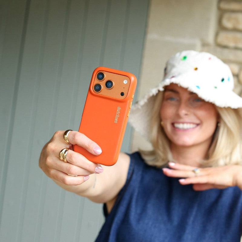 iPhone Case | Orange (Full Wrapped) being held by a smiling woman in a hat, showcasing the stylish design.