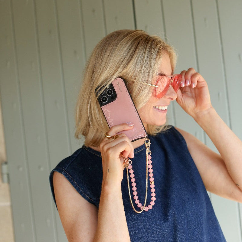 Phone Charm | Beaded | Jeanne worn by a stylish woman holding sunglasses and showing off her pink phone charm.