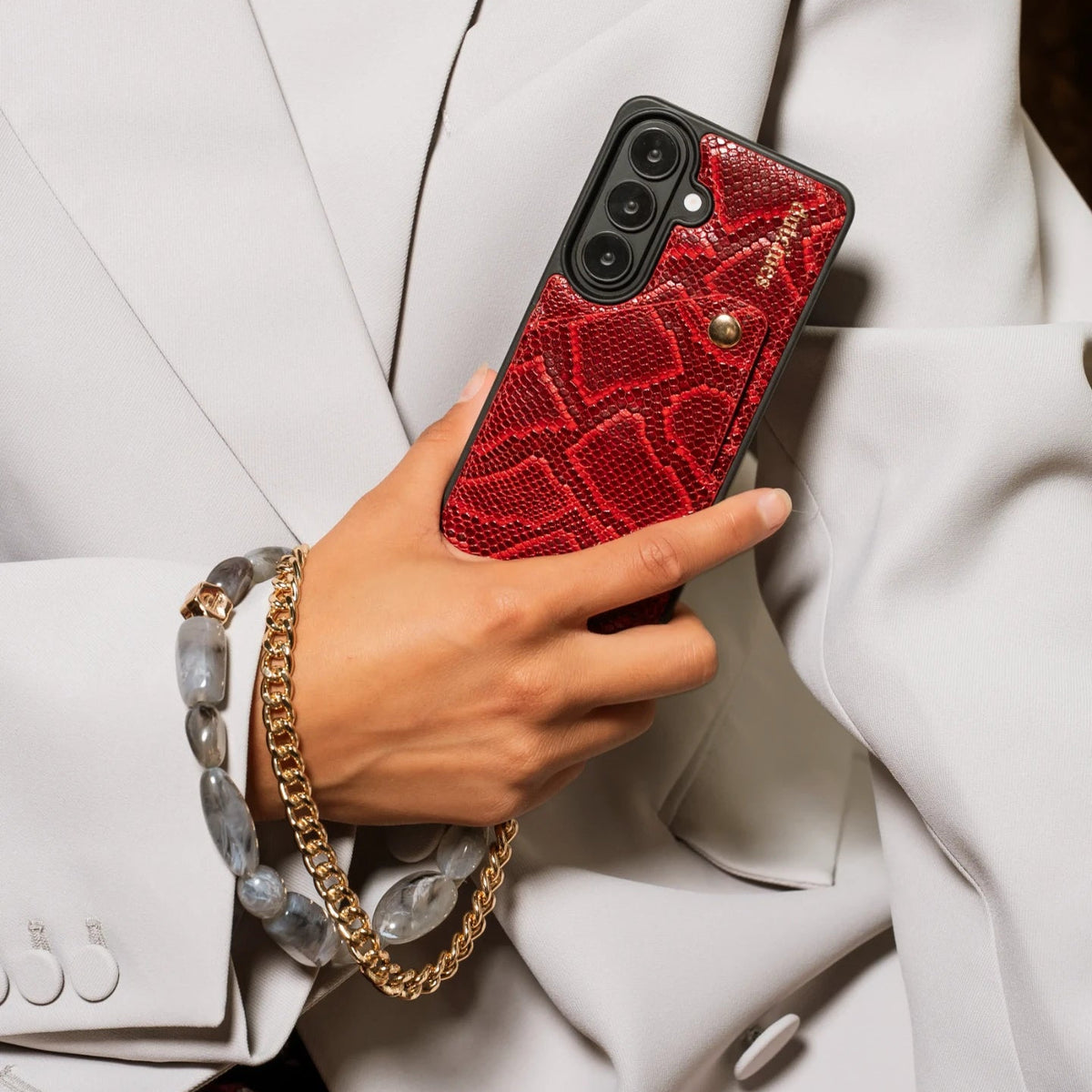Phone Charm | Beaded | Ada with a stylish red phone case and beaded bracelet in a fashionable setting.