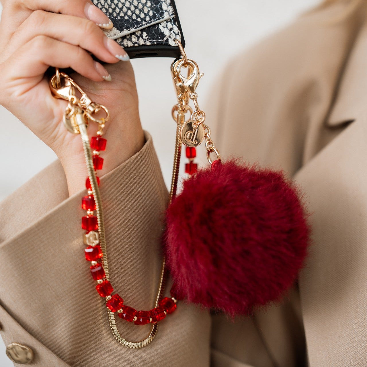 Phone Charm | Beaded | Hedy displayed with red glass beads and fluffy red pom-pom for stylish phone wristlet.