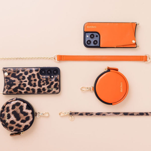 Phone Chain | Spanish | Orange with leopard print cases and accessories on a light background.