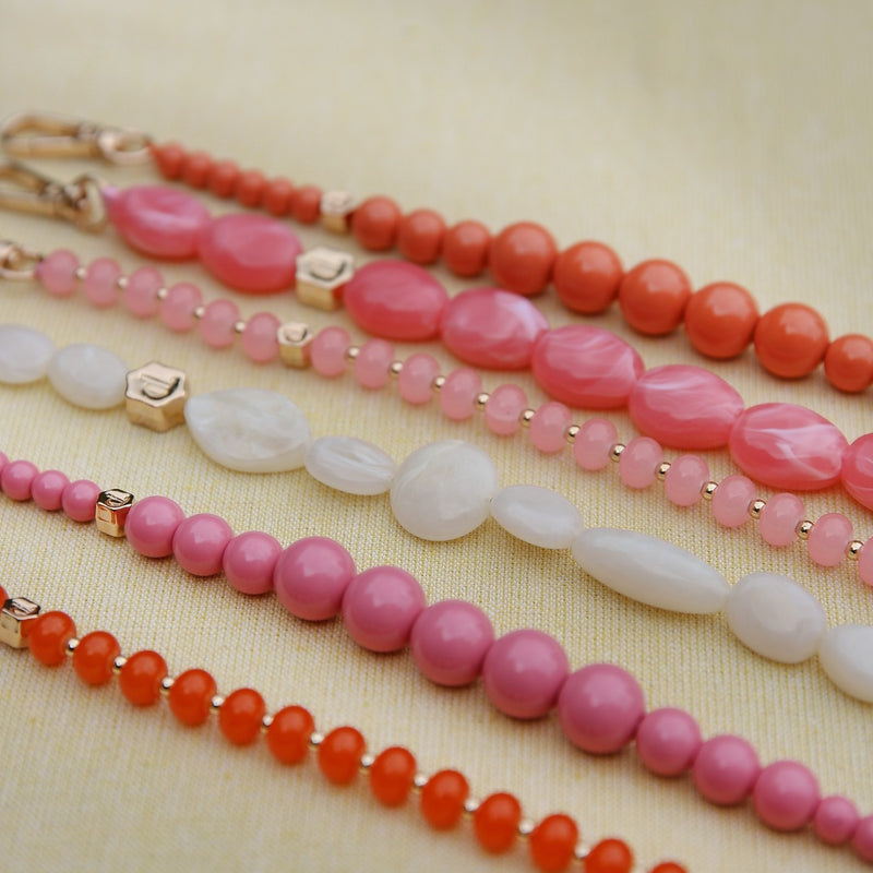 Colorful beaded phone charm straps in pink and orange hues, showcasing the vibrant details for the Phone Charm | Beaded | Alexandra.